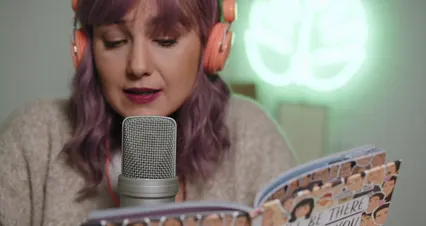 Horizontal video: A woman reading a book on a microphone 6953420. Duration: 31 seconds. Resolution: 4096x2160