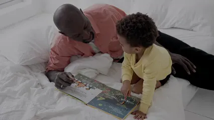 Horizontal video: Father and son reading a book on bed 8171868. Duration: 10 seconds. Resolution: 3840x2160
