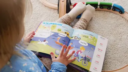 Horizontal video: Little girl sitting on the floor and looking in a colorful book 4016496. Duration: 11 seconds. Resolution: 3840x2160