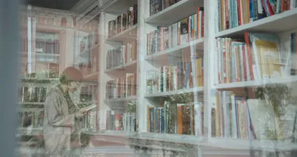 Horizontal video: A woman is looking at books in a library 4873466. Duration: 92 seconds. Resolution: 4096x2160