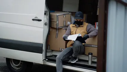 Horizontal video: Delivery guy sitting inside the van while reading the delivery details 6406111. Duration: 21 seconds. Resolution: 1920x1080